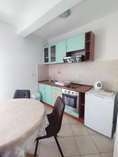 a kitchen with a table and two chairs and a table and a stove at Ravkin Apartments in Zadar