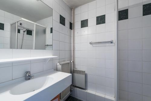 une salle de bain blanche avec un lavabo et une douche dans l'établissement Résidence Curling B3 - Studio au Curling B3 MAE-7784, à Tignes