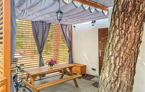 a wooden picnic table with a bike next to a tree at 2 Bedroom Beautiful Home In Lubniewice in Lubniewice