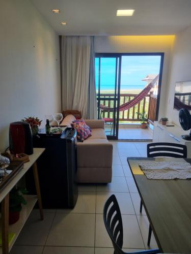 a living room with a couch and a view of the ocean at Vg Sun Cumbuco C1407 Studium in Cumbuco