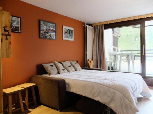 - une chambre avec un lit aux murs orange et une fenêtre dans l'établissement Résidence Palafour - Studio exposé sud au coeur de la station MAE-2154, à Tignes