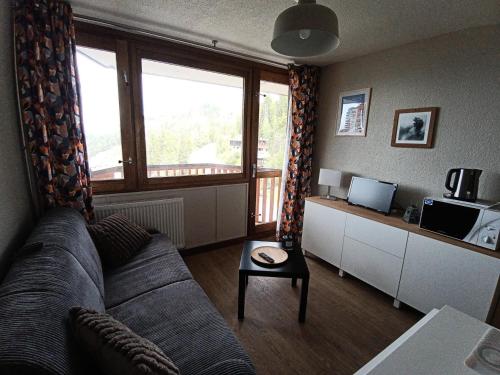un salon avec un canapé et une grande fenêtre dans l'établissement Résidence Le France - Studio 2 personnes Plagne Centre MAE-2844, à Aime La Plagne