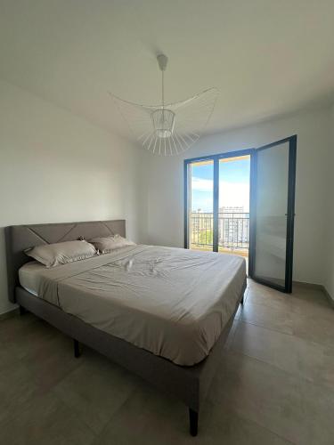 une chambre avec un grand lit et un lustre dans l'établissement Appartement Miramare, à Bastia