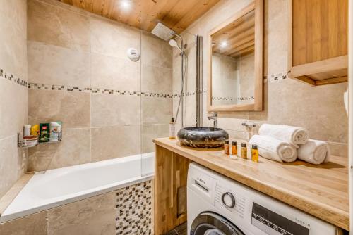 une salle de bain avec baignoire et machine à laver dans l'établissement Résidence Tour Du Lac - Grand 3 pièces 5 personnes - 55m2 - 3 MAE-9204, à Tignes