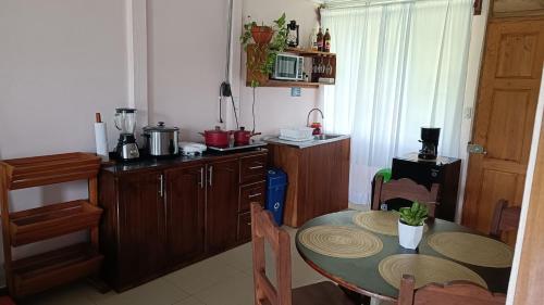 a kitchen with a table and a small kitchen with a table and chairs at Casa de Campo Heliconia in Fortuna