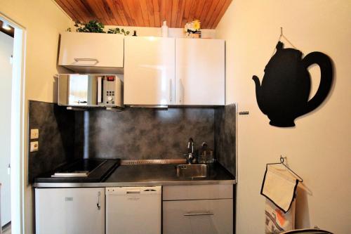 une cuisine avec un évier et un micro-ondes dans l'établissement Les Hauts Du Val Claret A - Au coeur de la station proche des pistes MAE-1234, à Tignes