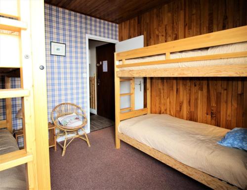- une chambre avec 2 lits superposés et une chaise dans l'établissement Les Hauts Du Val Claret A - Au coeur de la station proche des pistes MAE-1234, à Tignes