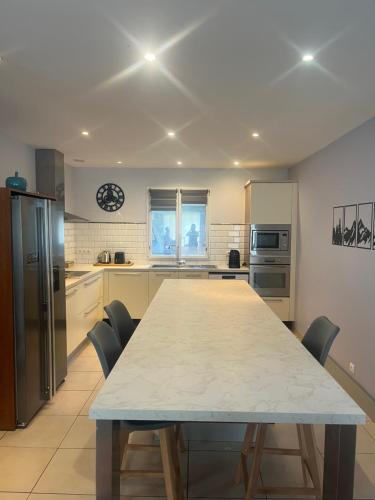 une grande cuisine avec une table et des chaises. dans l'établissement Maison familiale, à Bôo-Silhen