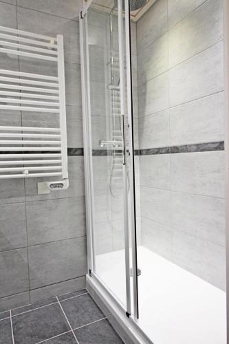 une douche avec une porte vitrée dans une salle de bain dans l'établissement Le Borsat - Idéalement situe dans la station MAE-1304, à Tignes