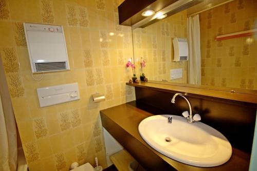 une salle de bain avec un lavabo et un miroir dans l'établissement Le Borsat - Studio au calme dans une résidence recherchée MAE-1354, à Tignes