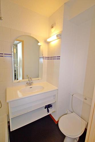 une salle de bain avec un lavabo, des toilettes et un miroir dans l'établissement Rond Point Des Pistes - studio fonctionnel au pied des pistes MAE-1434, à Tignes