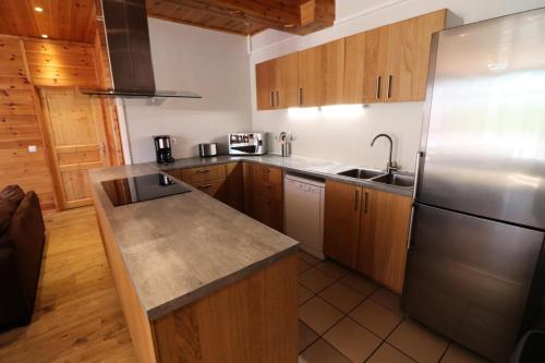 une cuisine avec des armoires en bois et un réfrigérateur en acier inoxydable dans l'établissement Résidence Grand Tichot B - Appartement 7 pièces Tignes Val claret MAE-2334, à Tignes