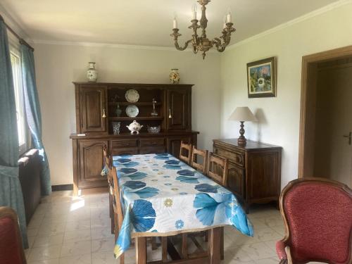 une chambre avec un lit, une table et un lustre dans l'établissement Chopiere, à Quiberville