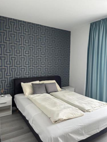 a large bed in a bedroom with blue curtains at Lux Penthouse Balatonlelle in Balatonlelle