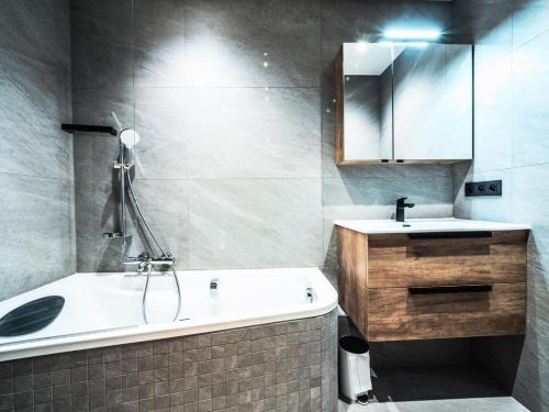 a bathroom with a tub and a sink and a mirror at Résidence Myrtilles - Appartement rénové·Proche des pistes·WIFI MAE-2394 in Tignes
