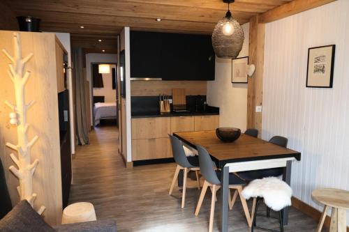 une cuisine et une salle à manger avec une table et des chaises dans l'établissement Résidence Curling A Tour - Appartement avec terrasse au sud à Tignes VC MAE-2404, à Tignes