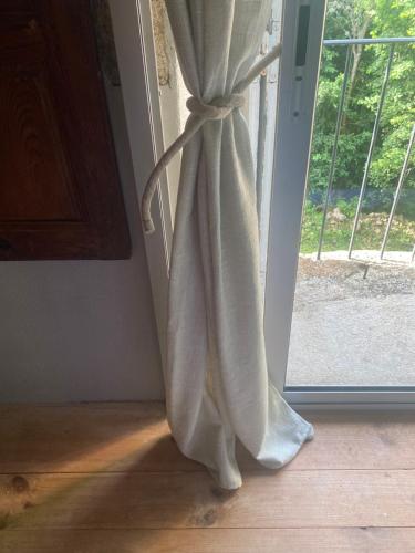 a white curtain hanging in front of a window at Le 1830 in Églisolles