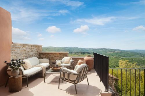 a patio with a couch and chairs on a balcony at Villa Motovun in Motovun
