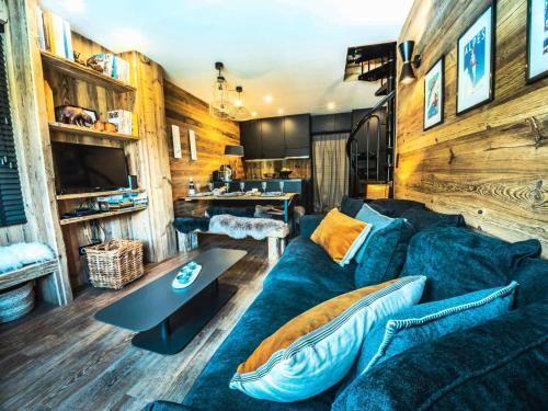 un salon avec un canapé bleu et une table dans l'établissement Résidence Hameau De Toviere - Duplex rénové·Proche pistes et commerces·Balcon MAE-2424, à Tignes