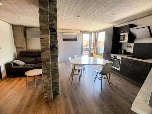 une cuisine et un salon avec une table et des chaises dans l'établissement Résidence Sefcotel - Appartement rénové·Proche des pistes ·Balcon MAE-2494, à Tignes