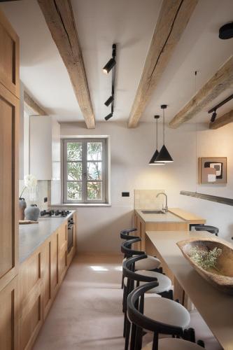 a kitchen with wooden ceilings and bar stools at Villa Motovun in Motovun