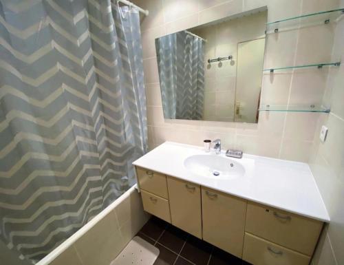 une salle de bain avec un lavabo et un rideau de douche dans l'établissement Résidence Bec Rouge - Appartement lumineux·Accès direct pistes·Balcon MAE-2484, à Tignes