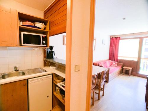 une petite cuisine avec un évier et une table dans l'établissement Résidence Hameau Du Borsat 3 - Appartement lumineux · Accès direct aux pistes MAE-2684, à Tignes