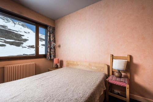 une chambre avec un lit et une fenêtre dans l'établissement Résidence Bec Rouge - Appartement lumineux·Skis aux pieds·Balcon MAE-2744, à Tignes