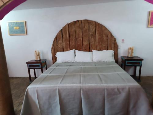 a bedroom with a large bed with a wooden headboard at HOTEL BACANTES in Puebla