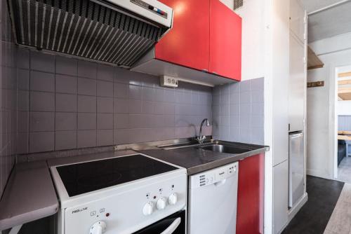 une petite cuisine avec un évier et une cuisinière dans l'établissement Résidence Bec Rouge - Appartement lumineux·Accès direct aux pistes·Balco MAE-2824, à Tignes
