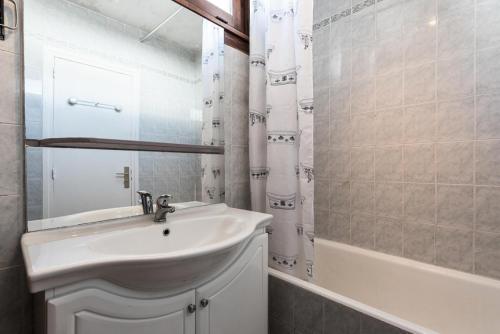 une salle de bain blanche avec un lavabo et une baignoire dans l'établissement Résidence Bec Rouge - Appartement lumineux·Accès direct aux pistes·Balco MAE-2824, à Tignes