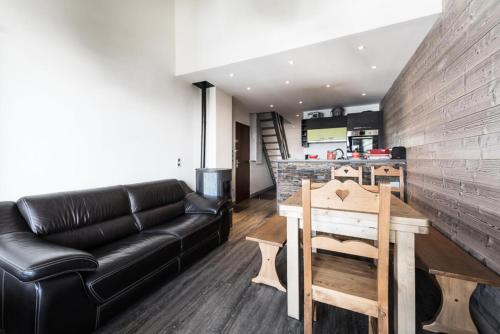 un salon avec un canapé en cuir et une table dans l'établissement Résidence Hameau De Toviere - Duplex rénové · Départ et retour skis aux pieds · MAE-1434, à Tignes