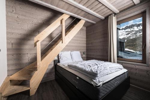 - une chambre avec une mezzanine et un escalier dans l'établissement Résidence Hameau De Toviere - Duplex rénové · Départ et retour skis aux pieds · MAE-1434, à Tignes