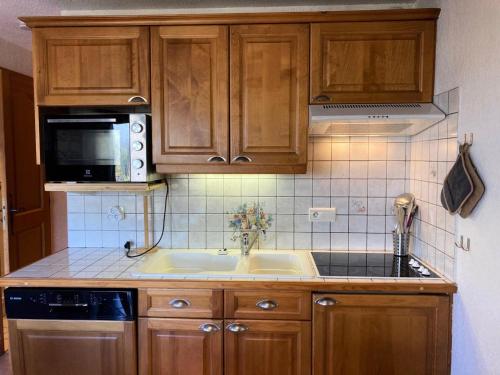 une cuisine avec un évier et un micro-ondes dans l'établissement Résidence Les Hauts De Chavants - 2 Pièces pour 4 Personnes 254, aux Houches