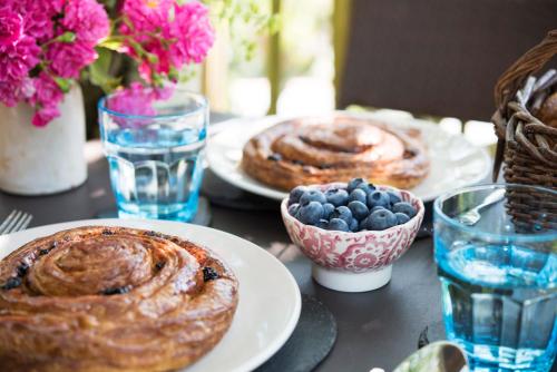 a table with plates of pastries and a bowl of blueberries at The Treehouse at Salcombe Farm in Salcombe