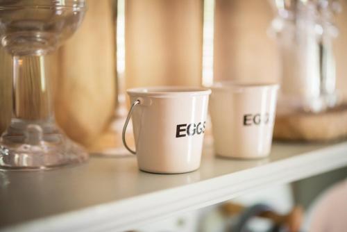 three coffee cups are sitting on a shelf at The Treehouse at Salcombe Farm in Salcombe