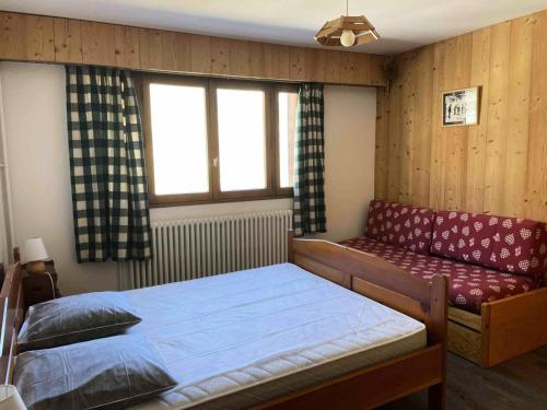 une chambre avec un lit, un canapé et une fenêtre dans l'établissement Résidence Soleil - Appartement rénové·Proche des pistes et des commer MAE-9394, à Tignes
