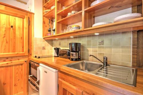 - une cuisine avec un évier en acier inoxydable et des placards en bois dans l'établissement Résidence Cerro Torre - Studio 2 personnes Plagne Centre MAE-2834, à Aime La Plagne