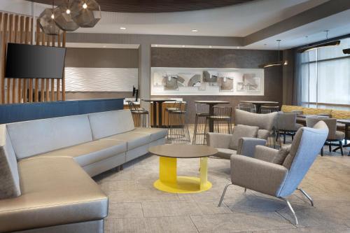 a lobby with a couch and chairs and a table at SpringHill Suites Orange Beach at The Wharf in Orange Beach
