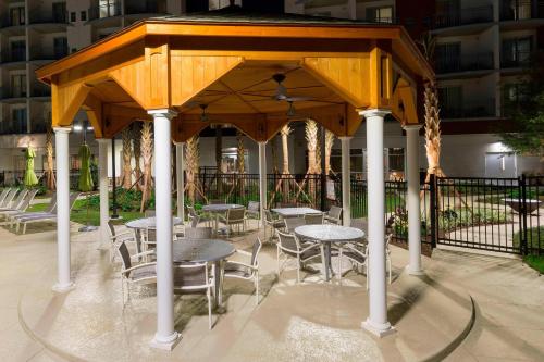 a gazebo with tables and chairs in a courtyard at SpringHill Suites Orange Beach at The Wharf in Orange Beach