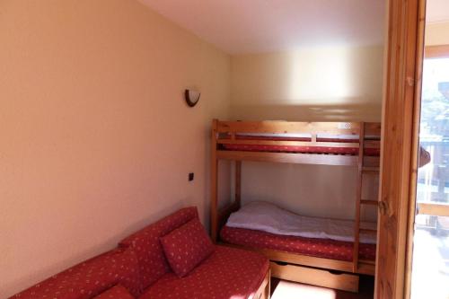 une chambre avec deux lits superposés et un canapé dans l'établissement Résidence Corail - Studio pour 4 Personnes 044, à Aime La Plagne