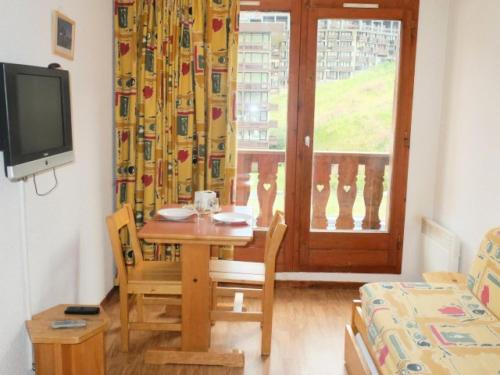 un salon avec une table et une télévision dans l'établissement Chalet Club Iii - Appartement proche des pistes et commerces·Balcon MAE-3584, à Tignes