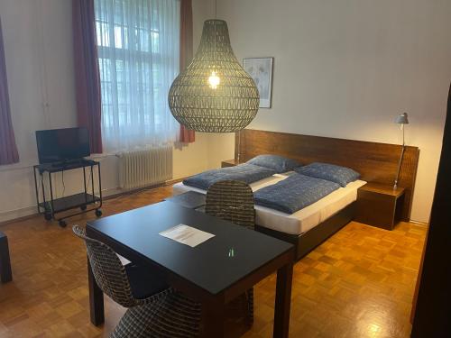 a bedroom with a bed and a table with chairs at WHLIVING - Apartments & Studios in Konstanz in Konstanz