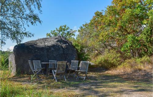 a table and chairs in front of a large rock at Beautiful Home In Ronneby With Sauna in Ronneby