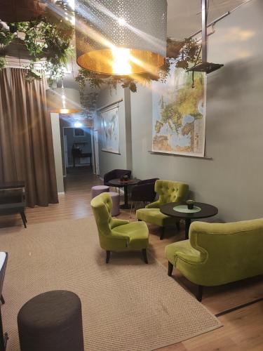 a waiting room with green chairs and tables at Sjugare Gård Bed & Breakfast in Leksand