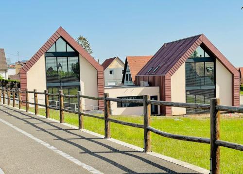 une clôture à côté d'une rangée de maisons dans l'établissement La Villa du Vignoble d Alsace, à Bennwihr