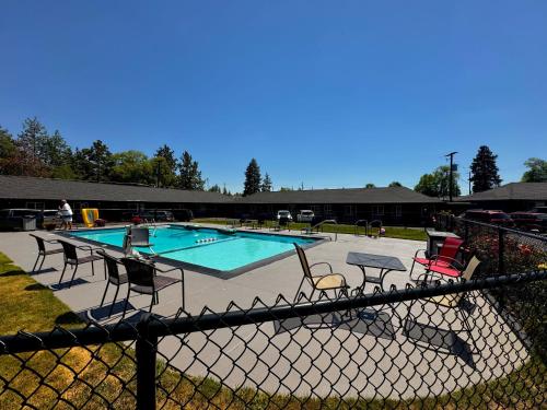 a swimming pool with chairs and a fence at Cascade Lodge - Central Bend Retreat in Bend
