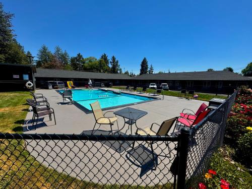a fence with chairs around a swimming pool at Cascade Lodge - Central Bend Retreat in Bend