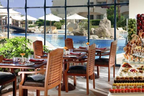 un restaurant avec des tables et des chaises ainsi qu'une piscine dans l'établissement Naama Bay Promenade Beach Resort Managed By Accor, à Charm el-Cheikh