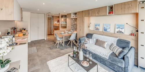 un salon avec un canapé bleu et une table dans l'établissement Résidence Palafour - Studio 4 rénové, soigné, confortable - balcon vue lac MAE-7954, à Tignes